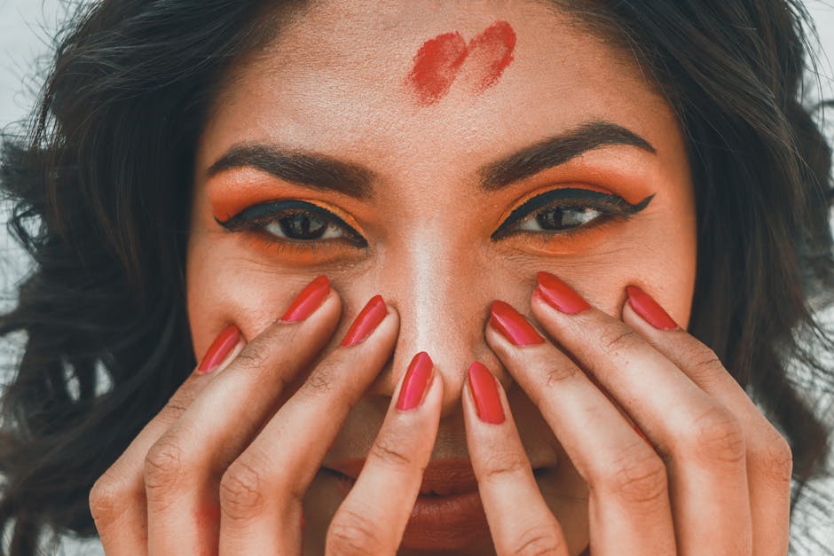 A bold red editorial nail look photographed close to the face