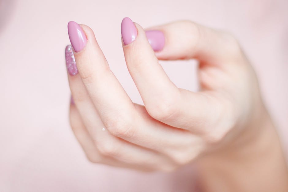 Hand with a clean pink press-on manicure