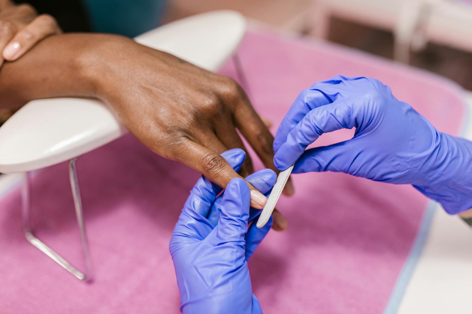 Close-up of a hand receiving a precise manicure application — illustrating press-on application technique.