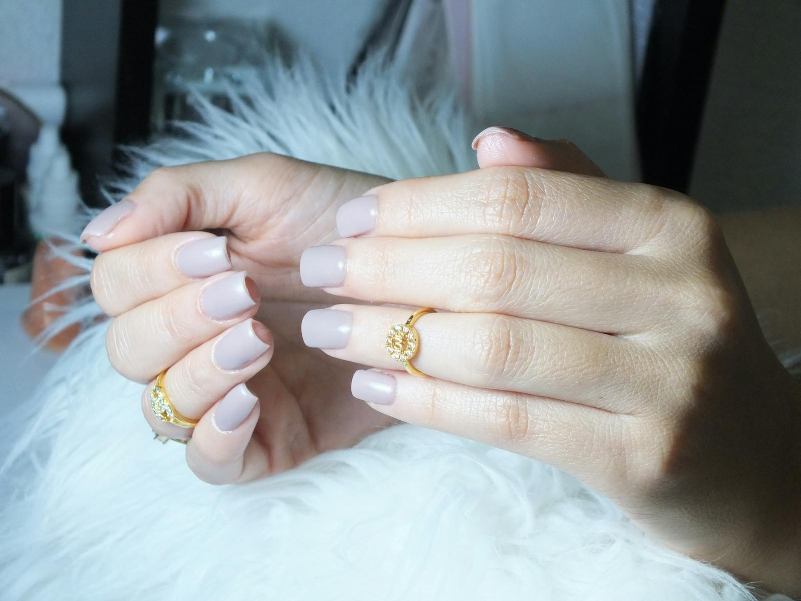 Manicured hands with neutral nails and gold rings — Olive and June vs Glamnetic press-on comparison lead image.