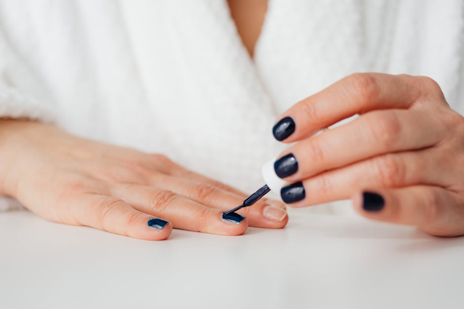 Person applying nail polish to fingernails