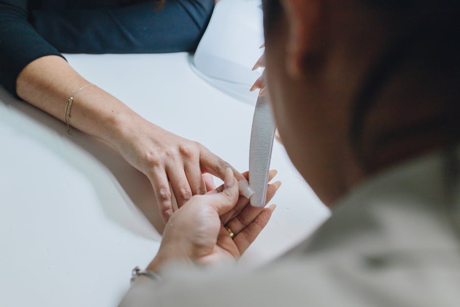Filing a natural nail in preparation for a press-on application